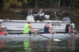 Coach in motorboat calls to four women in rowing shell