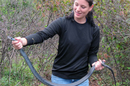 student with black racer snake