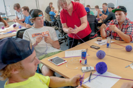 students knitting purple caps for babies