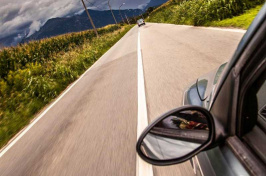 view from a car window towards a car on the road up ahead