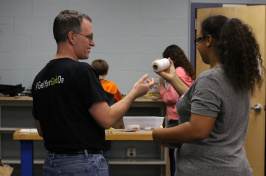 STEM docent Eric Swanson works with student.