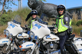 UNH police with their motorcycles in front of the wildcat statue