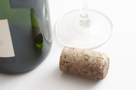 A wine bottle and cork next to a wine glass