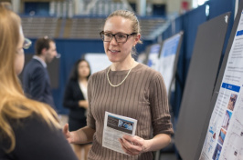 Graduate student Allison Leach in front of a research poster