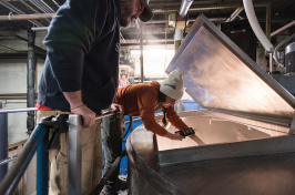 Smuttynose brewer Hannah Johnson ’12 reaching into a brewing container