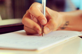 a close-up of a person writing in a notebook