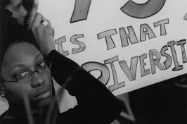 a UNH student holding a poster calling for increased recruitment of minority students and faculty (Photo: University Archives)