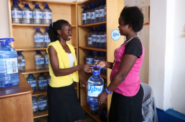 A woman purchases water from a Jibu franchisee.