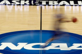A player runs across the NCAA logo during practice in Pittsburgh before an NCAA tournament basketball game in 2012. (Keith Srakocic / Associated Press)