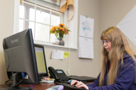 A member of the UNH community at work at a computer