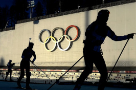 skiers in front of the olympic rings