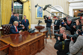 President Donald Trump hands over his pen after signing his first executive order in the Oval Office of the White House in Washington on Jan. 20. AP