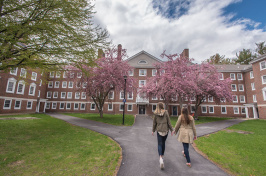 Two students walking through UNH's upper quad in the spring