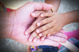 Image of grandparents' hand holding a child's hand