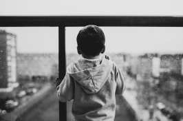 Image of child looking out a window