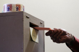 image of voter planning a ballot in box-photo credit: The Boston Globe