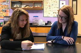 photos of two women in classroom reviewing paperwork