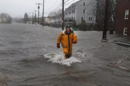 A rescue worker walked through flooded Sea Street during the first nor’easter of March. (JOHN TLUMACKI/GLOBE STAFF)