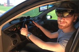 Man sitting in a driving simulator wearing augmeted reality goggles