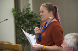 Postdoctoral researcher Kerri Seger speaks into a microphone