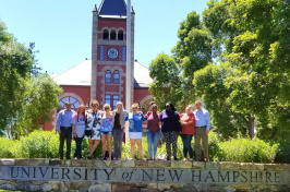 Daniel Silverman and residents of Lydia's House of Hope pose on the UNH wall on the Thompson Hall lawn