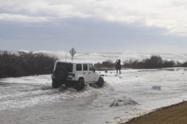 A driver ventures down a flooded road made impassable by coastal flooding in Rye, N.H. Photo credit: Kim Reed.