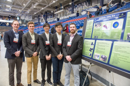 Five CEPS students standing beside a poster at URC