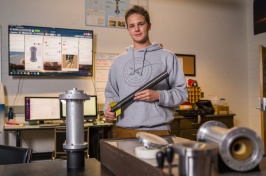 Charlie Nitschelm ’20 in a lab with parts of a rocket he's made.