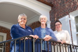 Penny Watson, Karen Gilbert, Jessica Willis on steps behind Hood House