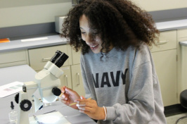 A student looks through a microscope 