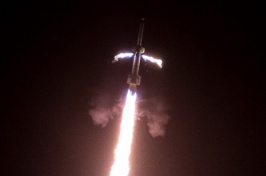 A rocket takes off with white-red flames behind it.