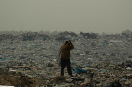 A young Palestinian walks through a debris-strewn field in Gaza where attacks have damaged much of the civilian infrastructure.