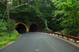 Roadway in rural America going beneath a tunnel.