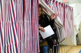 A women exits a voting booth 