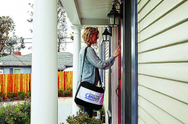 A woman working for the U.S. Census Bureau knocks on the door of someones home