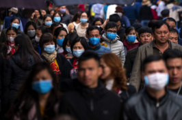 Masked people walk on a busy street