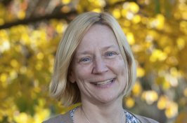 person smiling with trees in the background