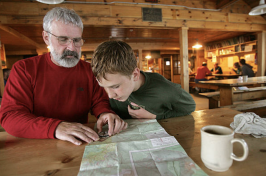 A father and son look at a map of New Hampshire