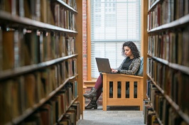 UNH online MBA student studying in the library