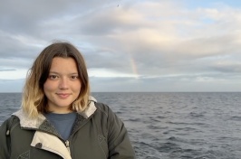 Emma McGuire in front of a rainbow