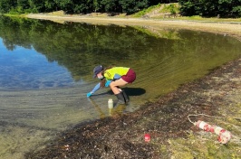 Researcher Christine Bunyon collects a cyanobacteria sample from Keyser Pond in Henniker, New Hampshire. 