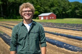 Eliudes Camps Marcano, an exchange student from Puerto Rico, stands in a field at the Kingman Research Farm, where he helped support agricultural research at UNH this past summer.