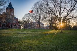 Thompson Hall at sunrise, with flag 