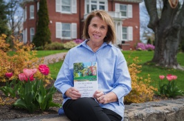 Jan Dean sitting outside of the president's house with her book