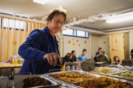 Woman stirs food in a heated tray