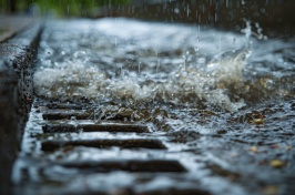 Close-up of stormwater drain with water gushing into it