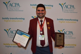 Man holding two awards in front of a white backdrop