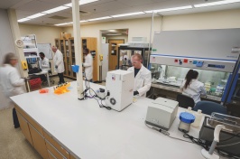 A wide shot of a lab, with several people working