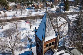 Aerial view of brick clock tower with dusting of snow on top
