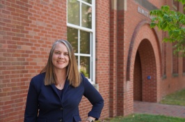 Cindy Hartman, UNH associate professor of recreation management and policy, standing outside a brick campus building.